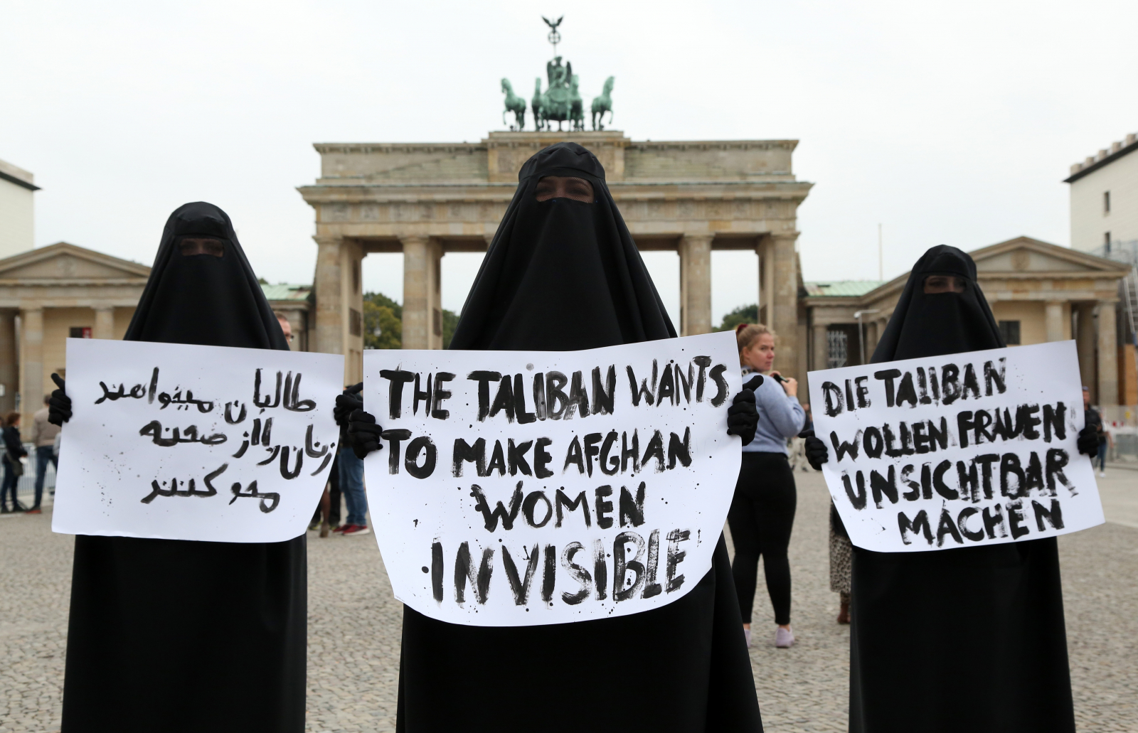 Członkinie feministycznej grupy aktywistek Femen noszą burki, protestując w solidarności z afgańskimi kobietami z transparentami z napisem „Talibowie chcą uczynić afgańskie kobiety niewidzialnymi” w języku perskim, angielskim i niemieckim, 25 września 2021 r. w Berlinie w Niemczech, wrzesień 2021 (Fot. Adam Berry/Getty Images)