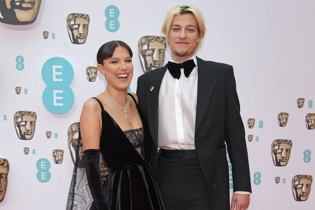 Millie Bobby Brown i Jake Bongiovi na gali BAFTA w 2022 roku, uśmiechając się do obiektywu.