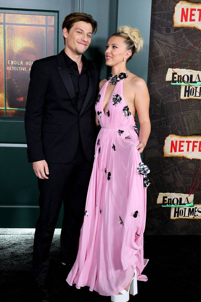Jake Bongiovi i Millie Bobby Brown na premierze filmu "Enola Holmes" w 2022 roku, oboje w eleganckich strojach.