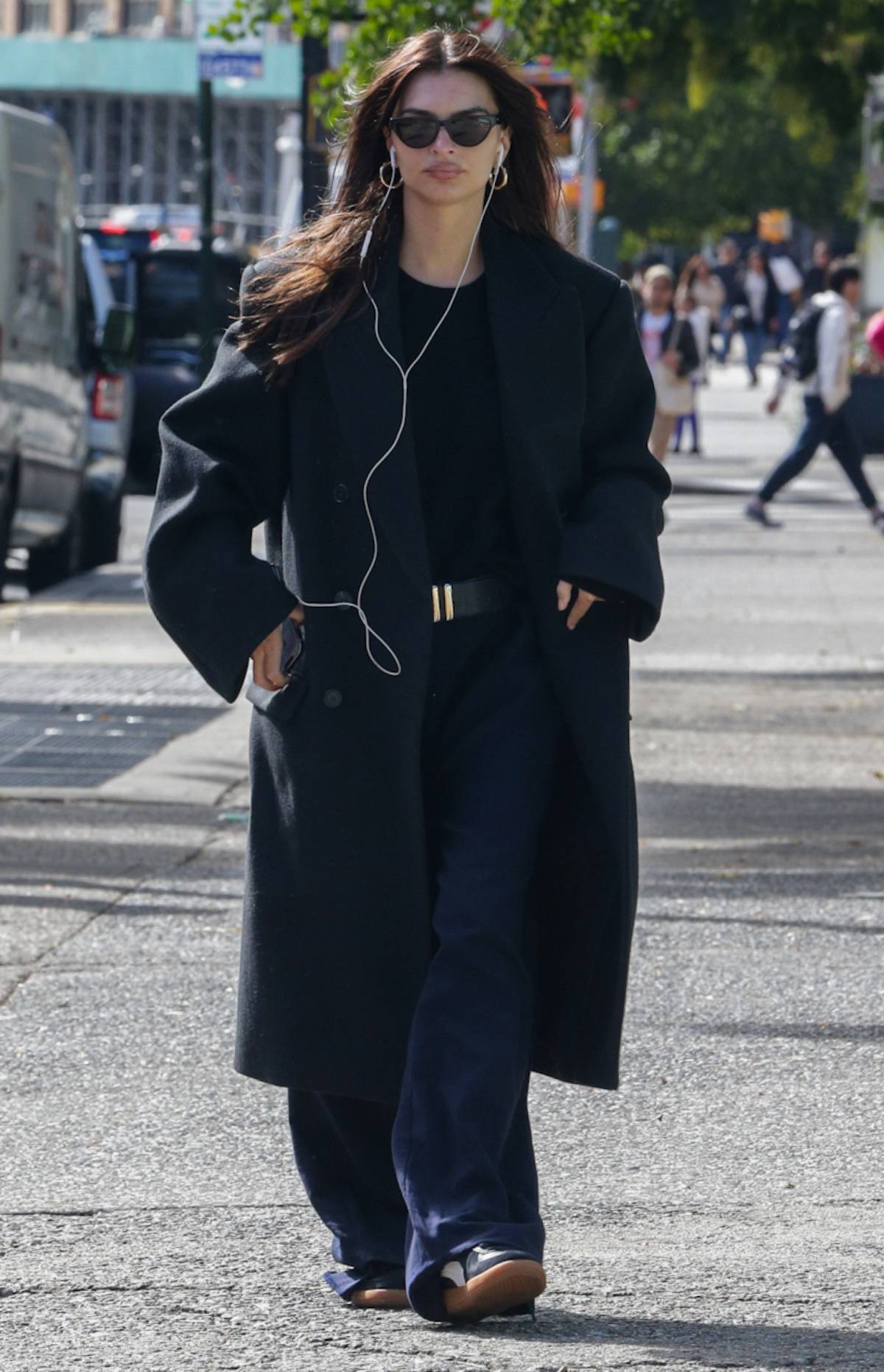 Emily Ratajkowski spaceruje po Nowym Jorku, ubrana w czarny płaszcz i luźne spodnie.