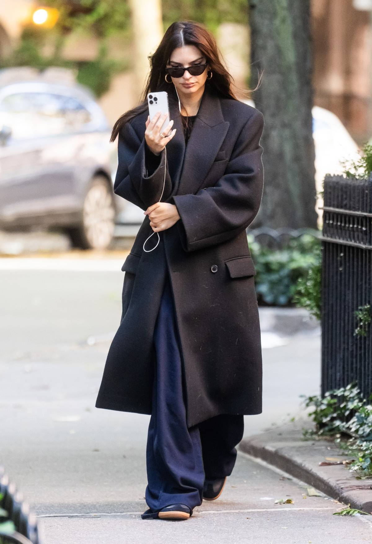Emily Ratajkowski spaceruje po Nowym Jorku, ubrana w czarny płaszcz i luźne spodnie.
